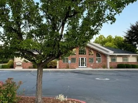 The Times Square Dental building in Boise, seen across the car park past a shade tree.