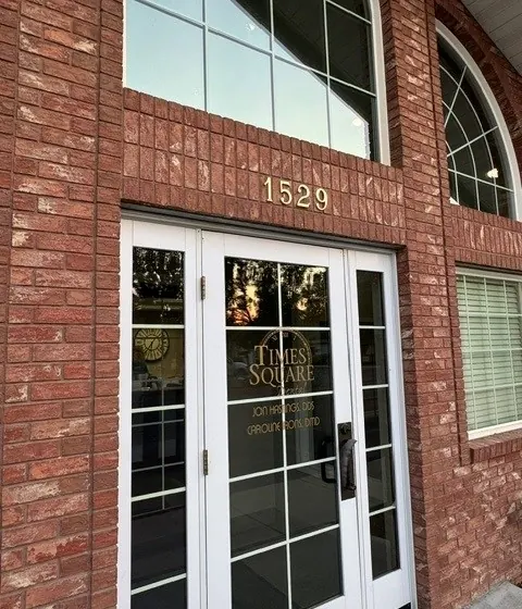The front doors of Times Square Dental under the brick gable marked 1529.